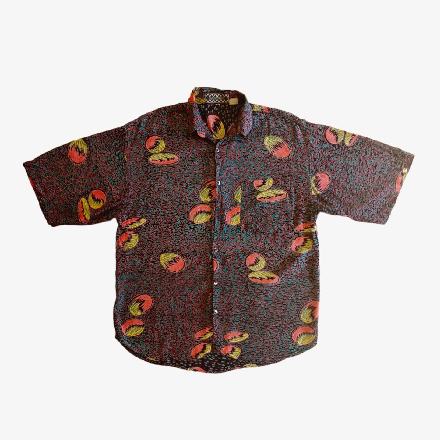A vintage 80s men's short sleeve shirt with an abstract multicolor print.