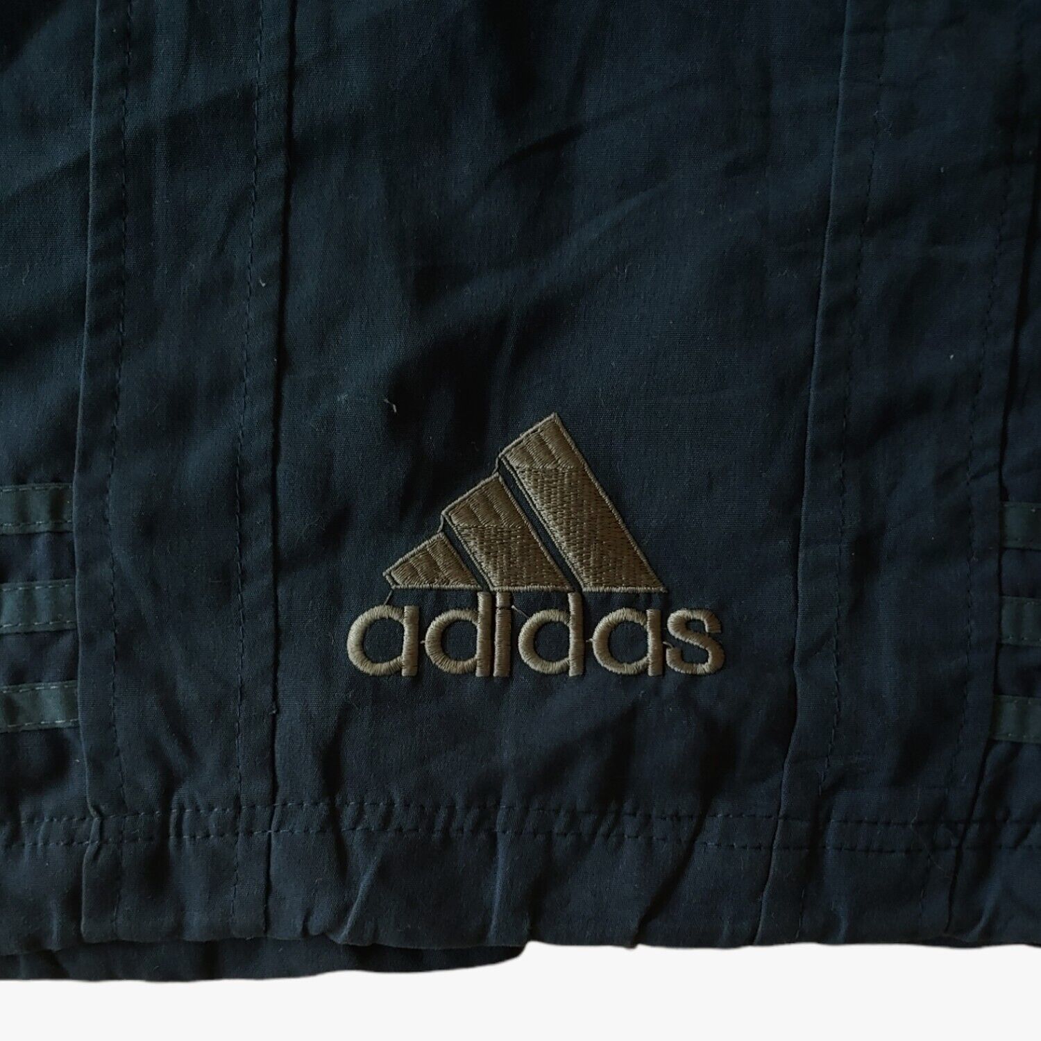 Embroidered hem of vintage 90s men's Adidas Equipment navy tactical vest.