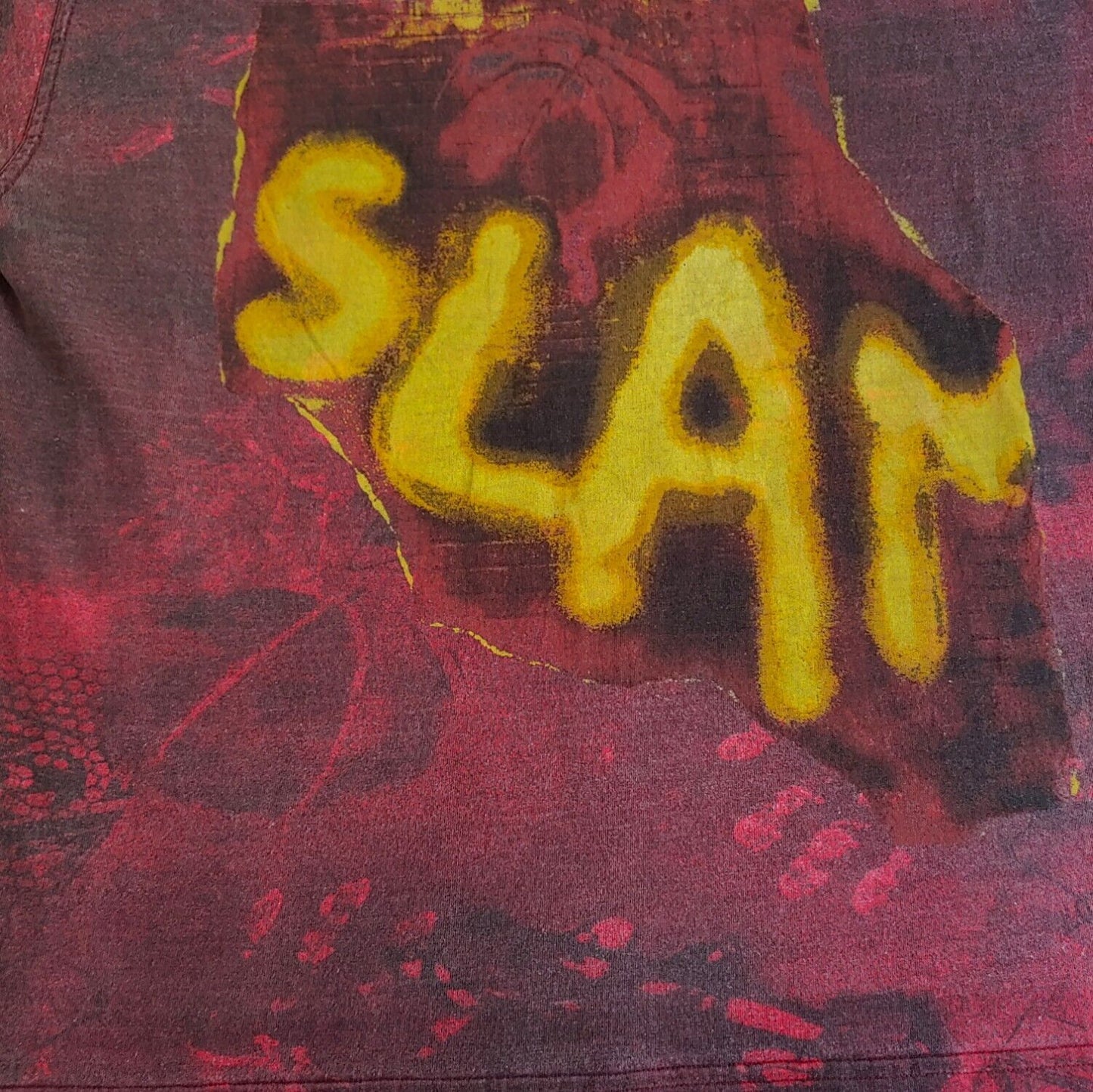 Close up of 'SLAM' printed in yellow bold letters on the front of vintage 90s men's Reebok tie-dye t-shirt.