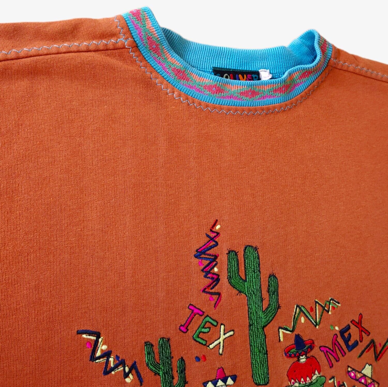 Patterned collar of vintage orange S.Oliver Mexico souvenir sweatshirt.