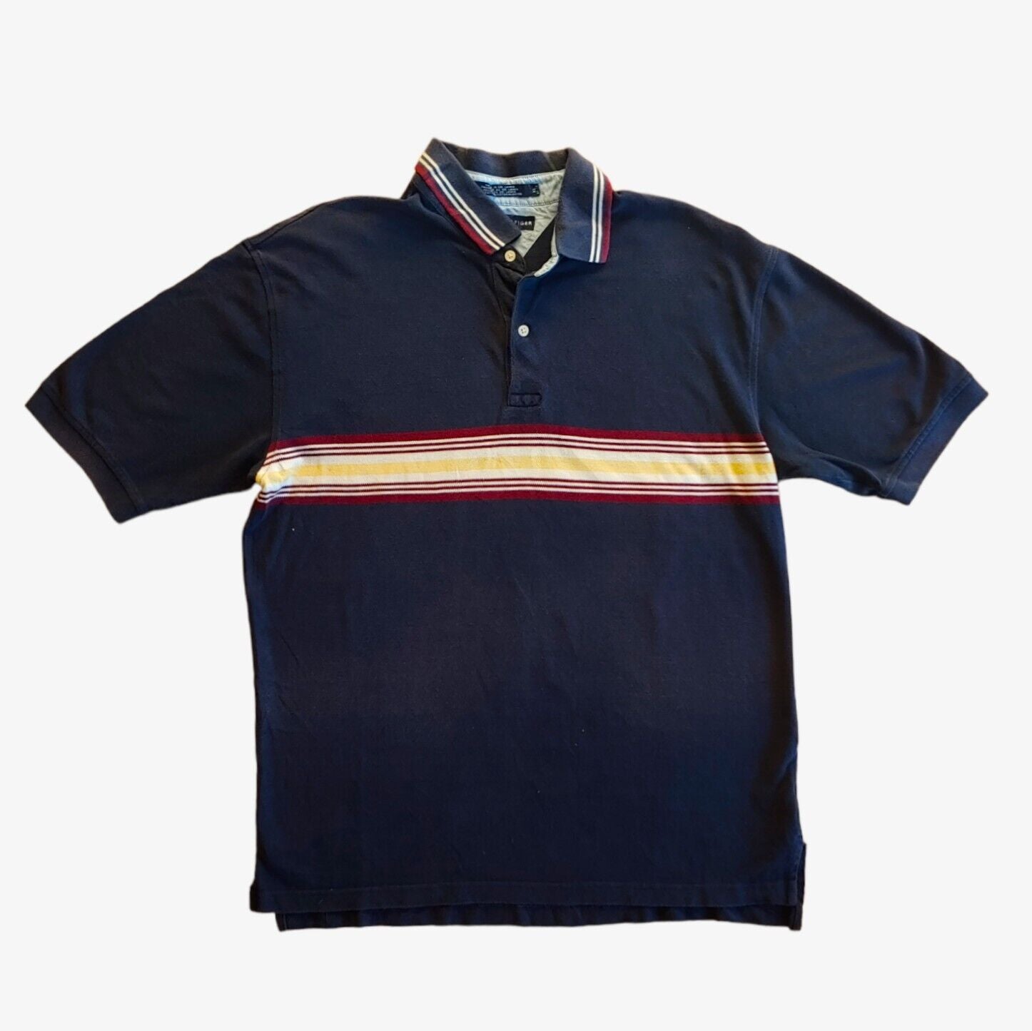 A vintage Tommy Hilfiger striped polo shirt in navy, with a colourful stripe, short sleeves, and a collar.