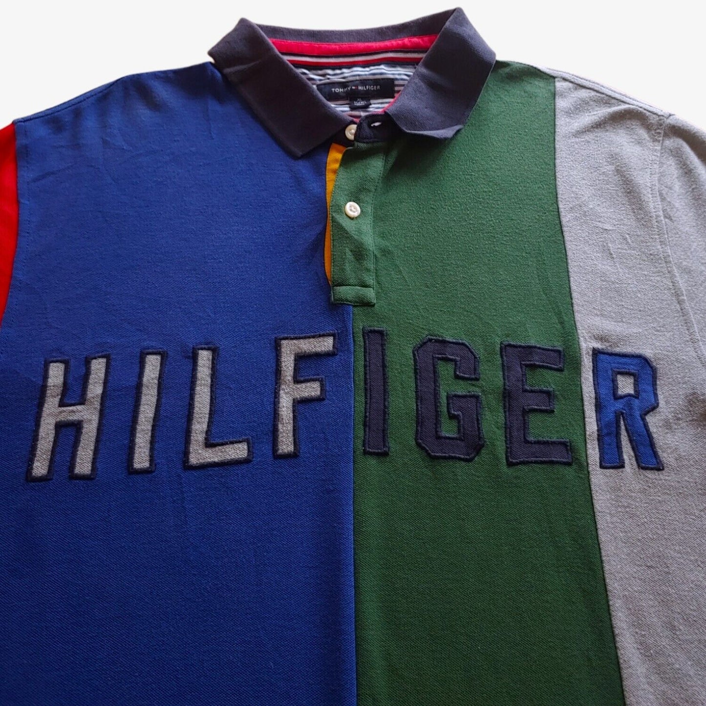 Close up of a colour blocked Tommy Hilfiger polo shirt with an embroidered chest logo.