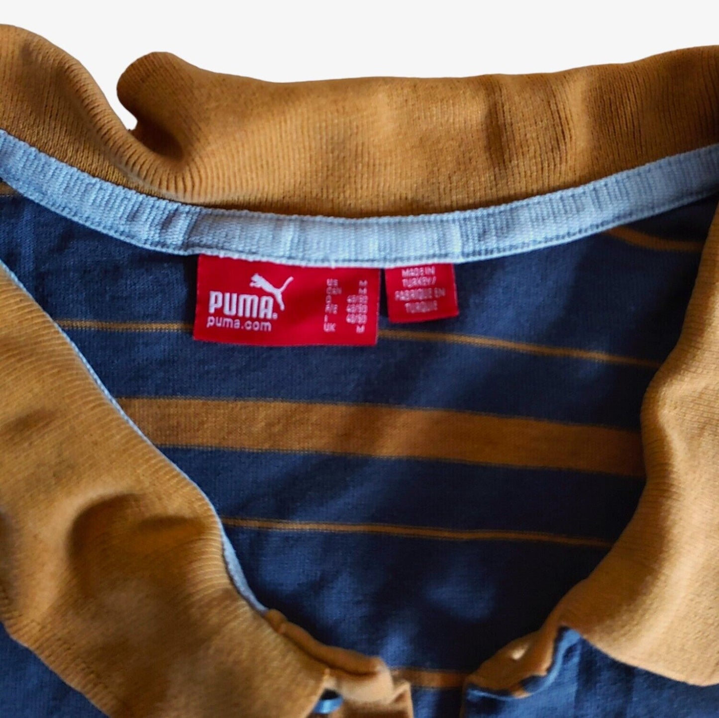 Label of vintage Y2K Puma Manu Samoa New Zealand striped rugby polo shirt.