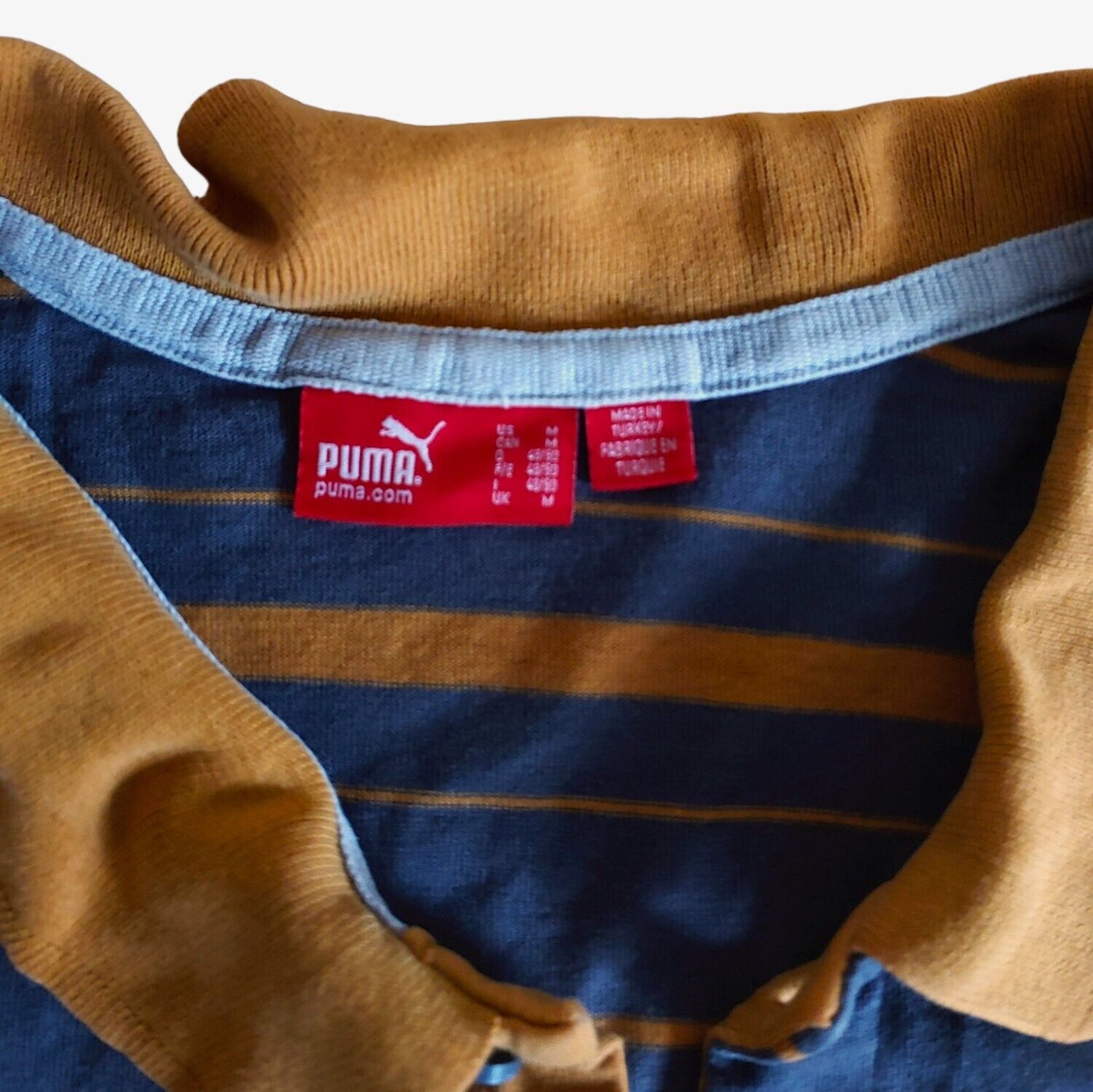 Label of vintage Y2K Puma Manu Samoa New Zealand striped rugby polo shirt.